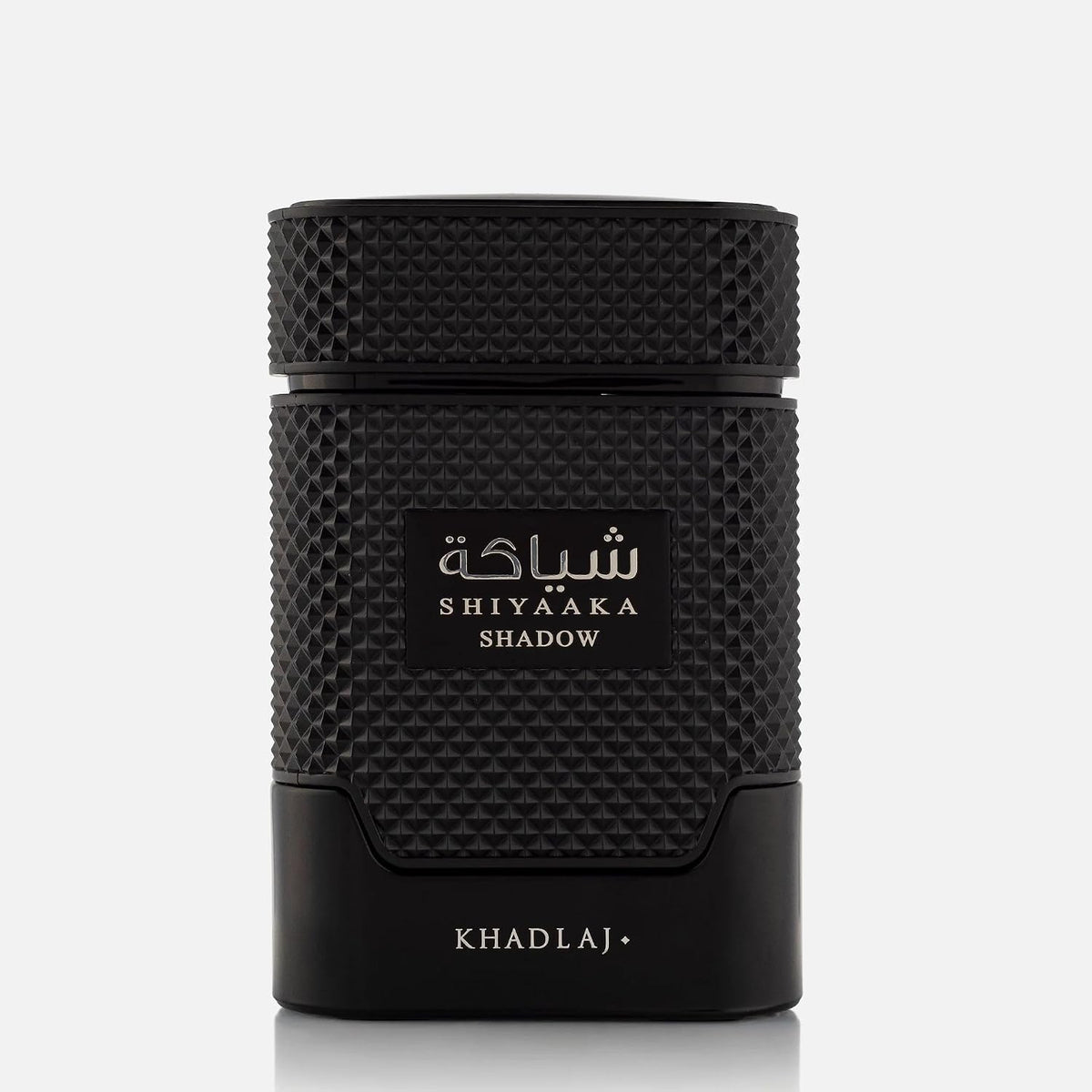 A black cylindrical cosmetic container with a textured grip and a central label reading 'SHIYAAKA SHADOW' in white Arabic and English text, with 'KHADLAJ' printed near the base, on a light gray background.