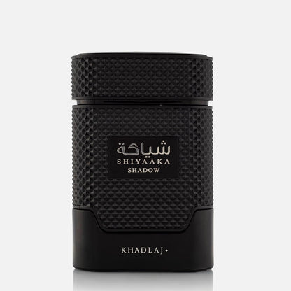 A black cylindrical cosmetic container with a textured grip and a central label reading 'SHIYAAKA SHADOW' in white Arabic and English text, with 'KHADLAJ' printed near the base, on a light gray background.