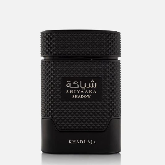 A black cylindrical cosmetic container with a textured grip and a central label reading 'SHIYAAKA SHADOW' in white Arabic and English text, with 'KHADLAJ' printed near the base, on a light gray background.