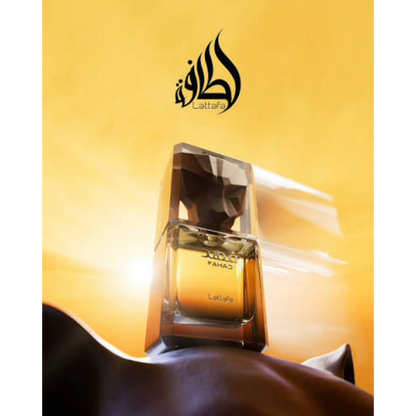 A bottle of Lattafa Fahad perfume with a faceted clear cap and amber-colored liquid, set against a warm golden-yellow background with the Lattafa logo above.