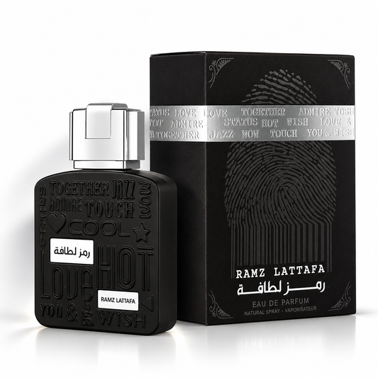 Lattafa Ramz Silver Eau de Parfum black perfume bottle with silver cap beside its matching black fingerprint-design box on a clean white background with soft shadows.