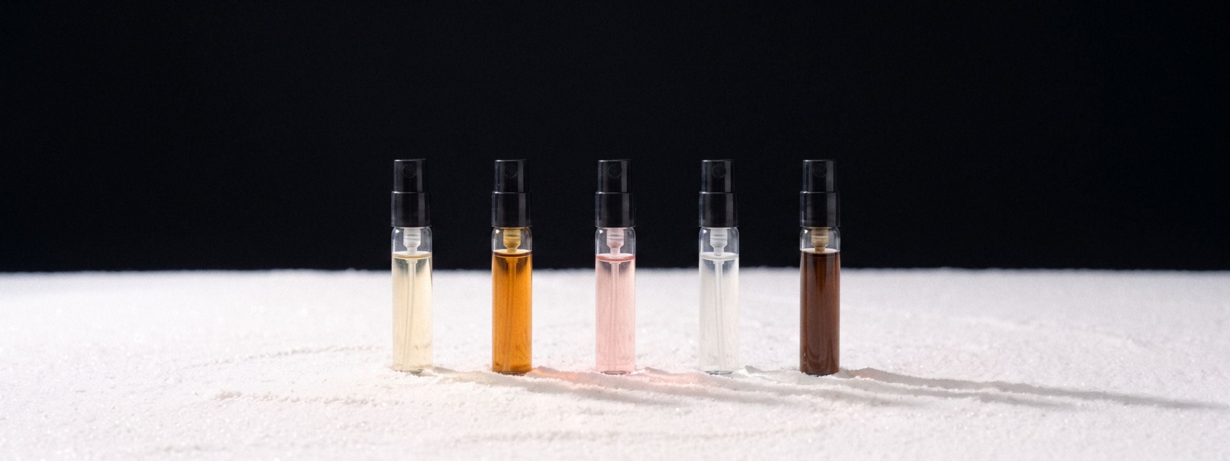 Five 2 ml vials in a row on a black studio plate